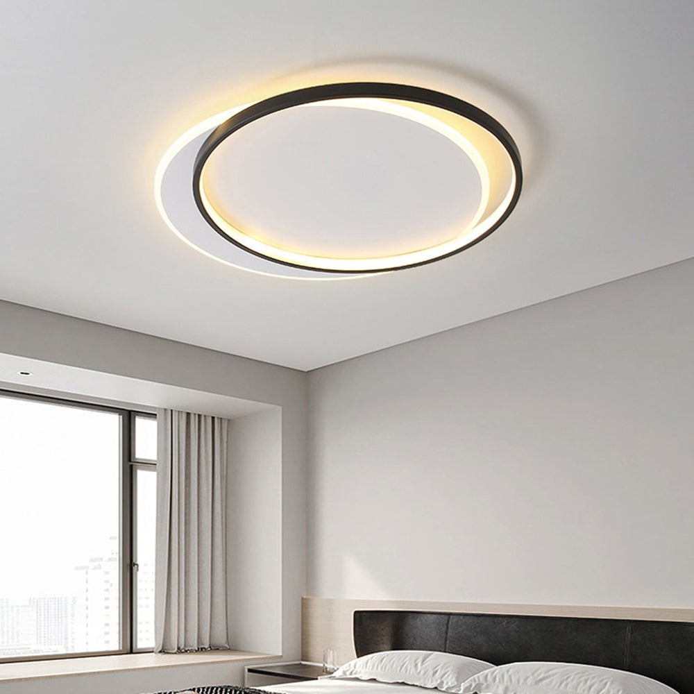 Round Quinn ceiling light above dark upholstered headboard in pale wood frame, with light bedding, window and white curtains.