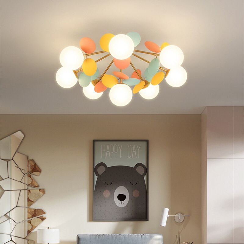 Jevon colourful globes and petals seen from below above framed bear artwork, with a mirror and tall cabinet nearby.