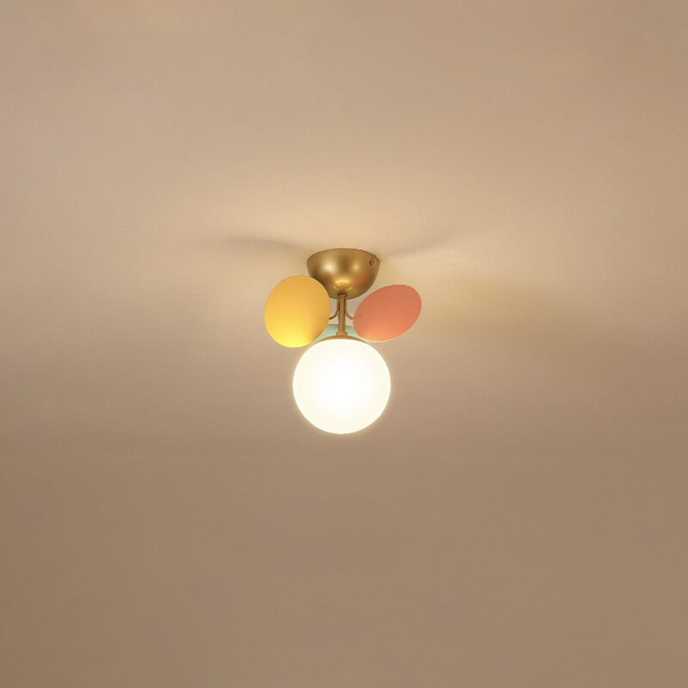 Single lit Jevon white globe with yellow and coral petals under a gold-tone bowl canopy on a pale ceiling.