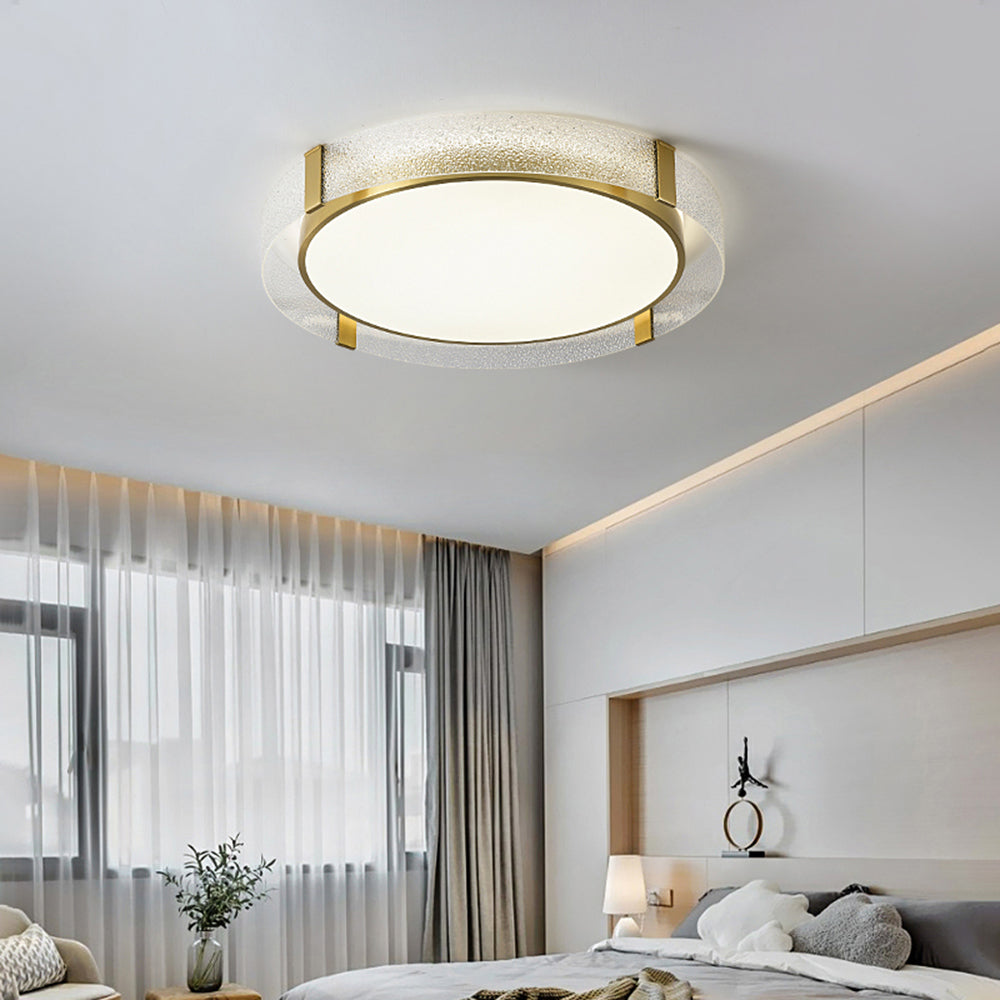 Quinn above a pale bed with white flower and grey heart cushions, recessed headboard niche, ring ornament, sheer curtains and a vase with plant.