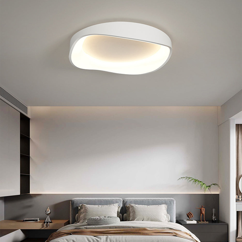 Single white Arisha bowl above a grey double headboard, light bedding, brown throw, dark cabinet and cove-light wall.
