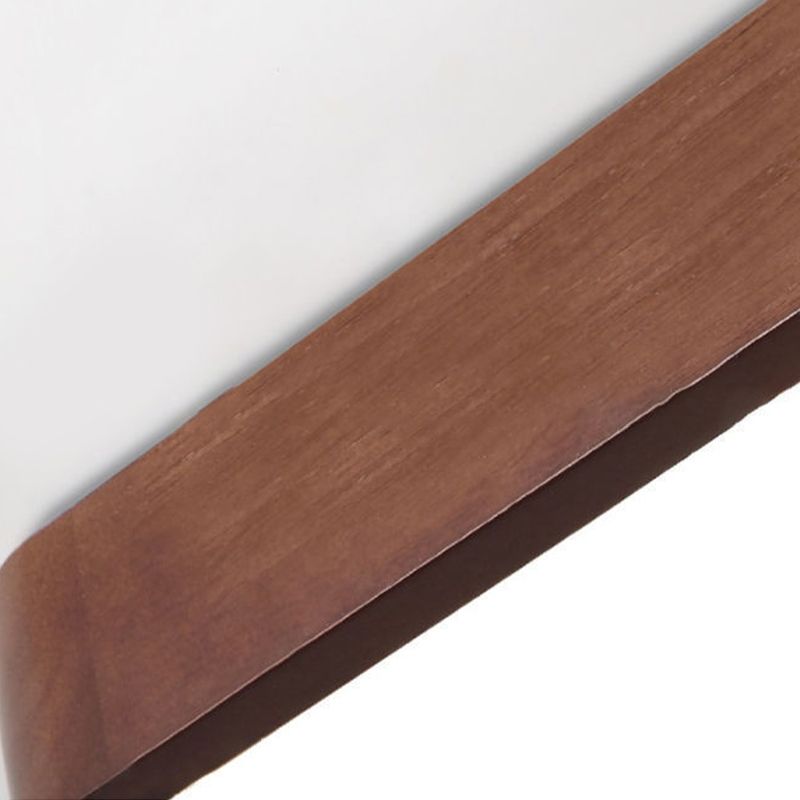 Close-up of a straight Ozawa brown wood-grain frame edge beside the bright pale acrylic face.