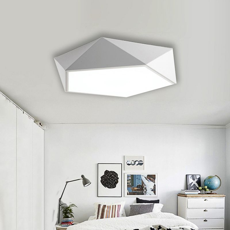 White Quinn above a bed with geometric artwork, striped pillows, desk-style lamp and dresser with a globe.