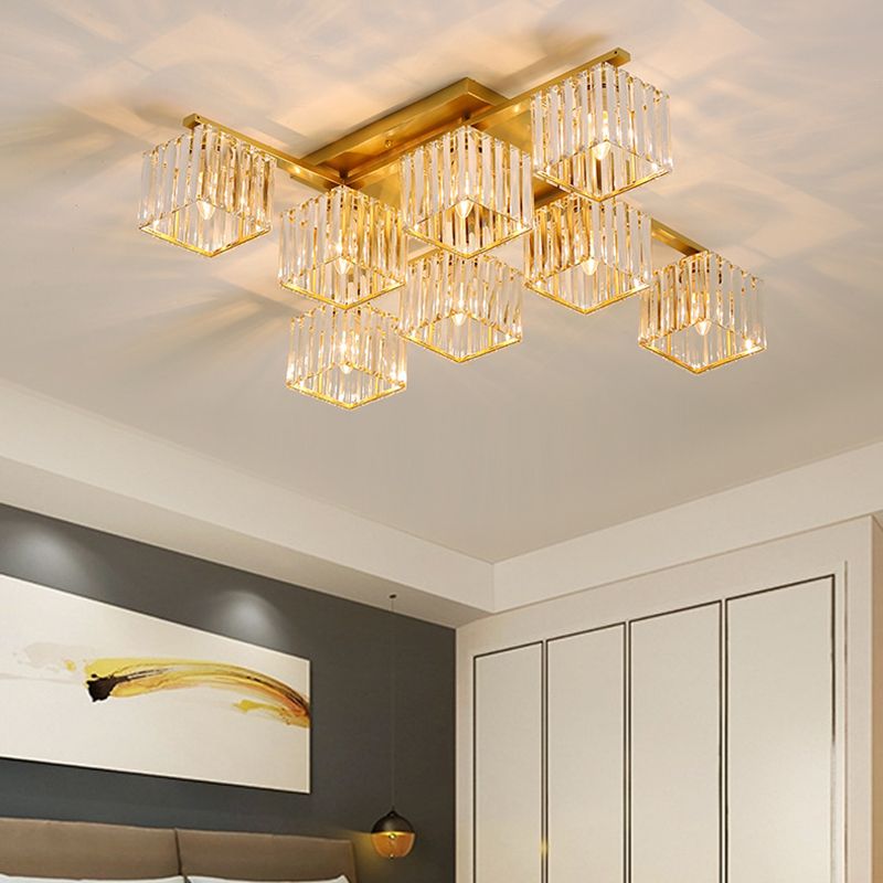 8-light Gold Kristy light above dark bedroom panels, black-and-yellow artwork, headboard and pale wardrobe doors.