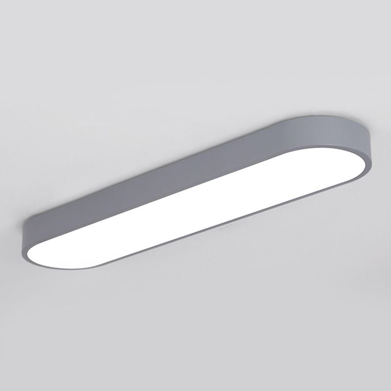 Gray Quinn capsule ceiling light with smooth sides and a filled bright lower face against a pale ceiling.