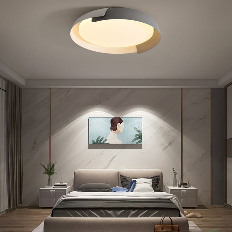 Warm-lit gray and light Quinn ceiling fixture above a gray bed and upholstered bench, with a marble-pattern wall and portrait artwork.