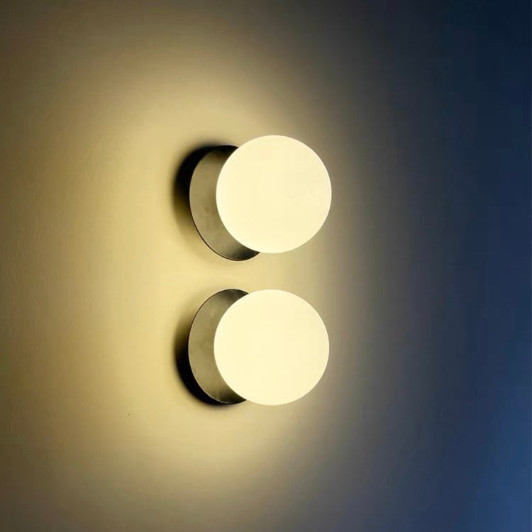 Two Black Valentina smooth white globe lights arranged vertically on a wall beside a blue area.