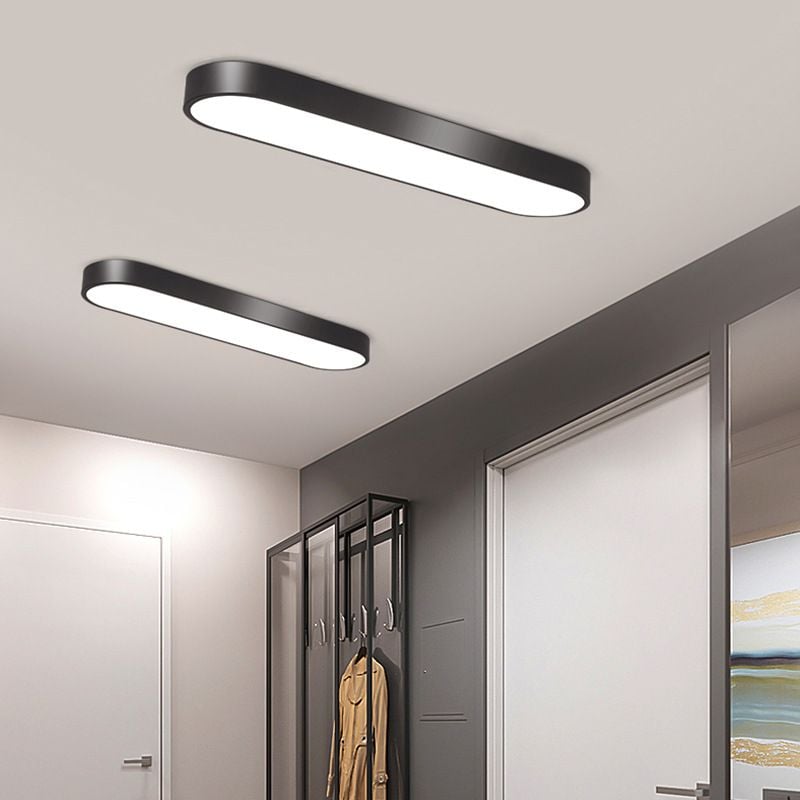 Two black Quinn ceiling lights with smooth sides above a gray coat rack and yellow jacket, beside a white sliding door.
