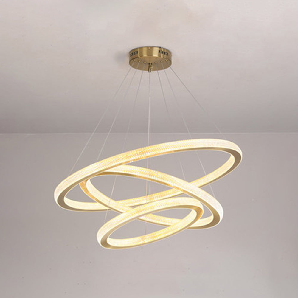 Closer ceiling view of three crossing Kirsten rings with textured lit bands, gold-tone rims and round vented canopy