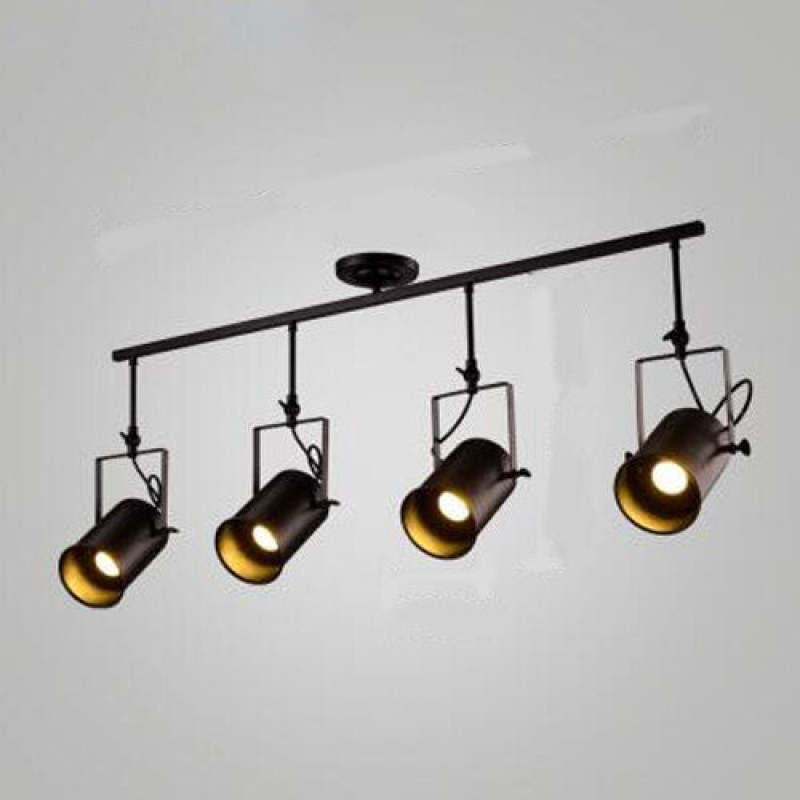 Four-head Alessio black bar on a pale wall, with warm-looking lit centers, differing head angles and squared brackets.