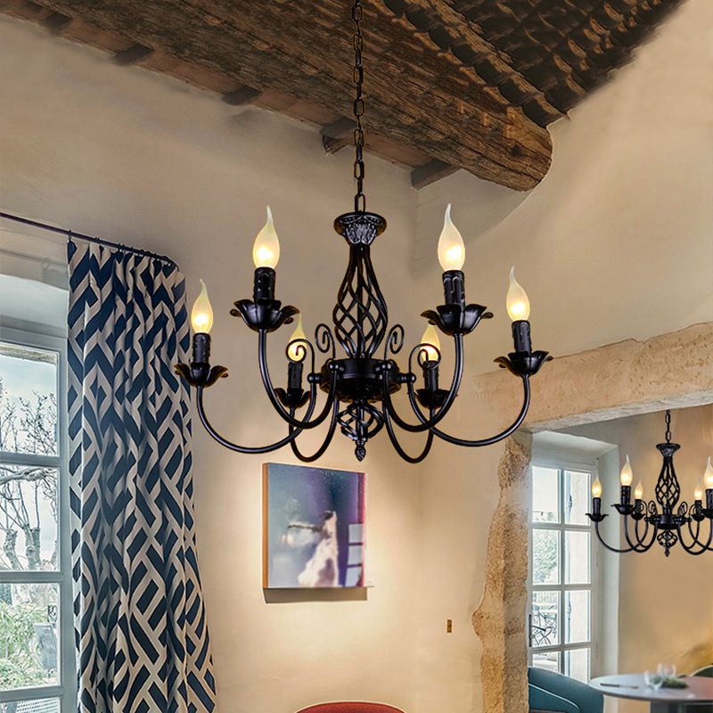 Black Silva six-light chandelier beneath rustic wood ceiling beside patterned blue curtains, with another fixture through doorway