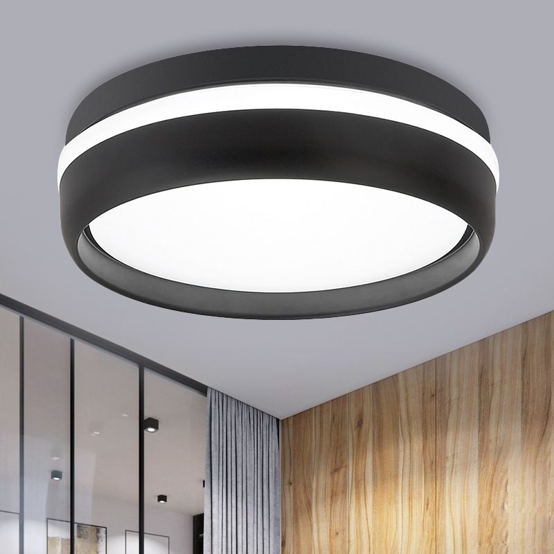 Close-up of a black Quinn ceiling light with white illuminated diffuser and side band beside a wooden wall