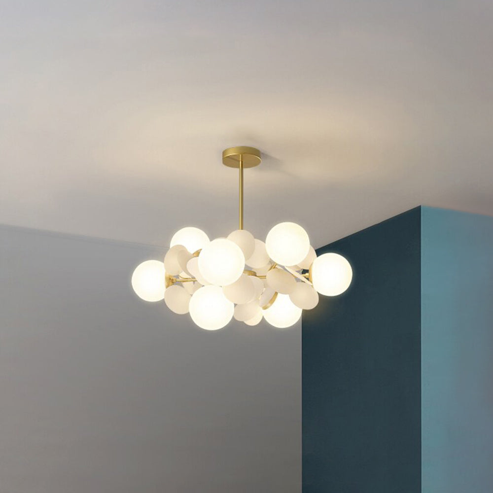Jevon White 23.6-inch 8-light option with pale petals and white globes on a short gold-tone stem beside a teal wall.
