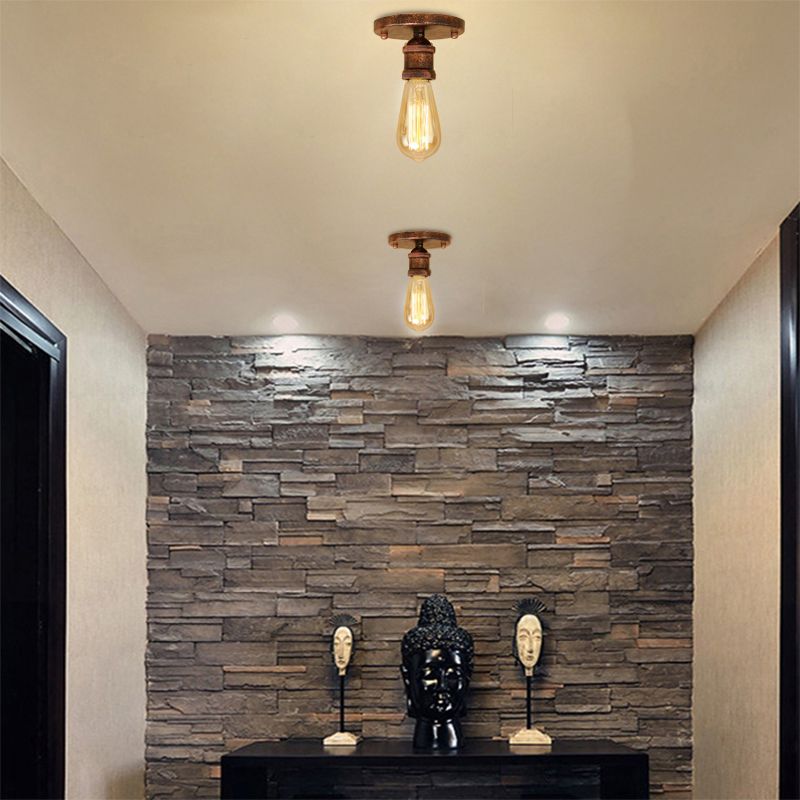 Two rust-tone Alessio exposed-bulb fittings above a stone feature wall, dark console and sculptures, with separate recessed lights.