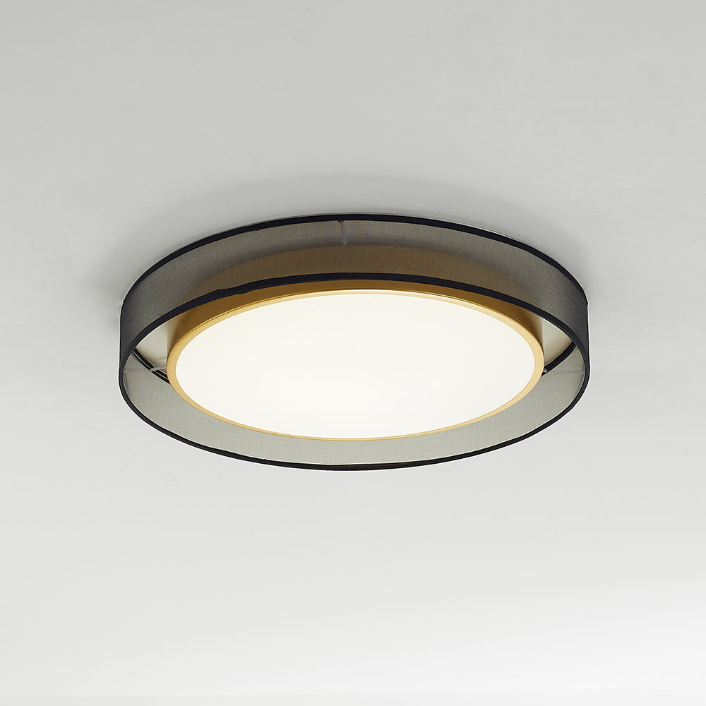 Quinn viewed obliquely from below with a bright pale diffuser, gold-tone rim and textured grey outer drum edged in black.