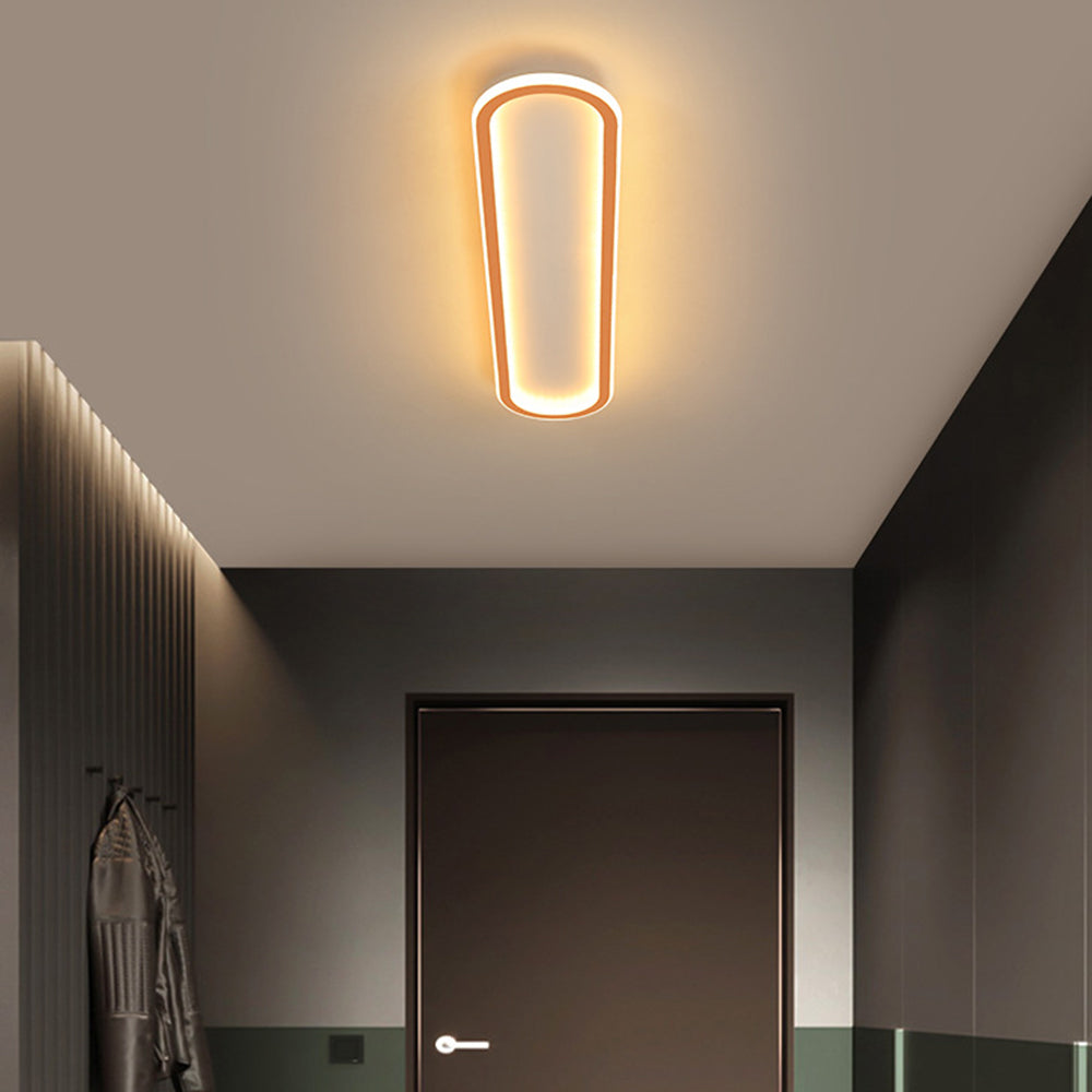 Rose Gold Quinn light above dark entry door, grey upper walls, green lower panels, slat detail and hanging jacket.