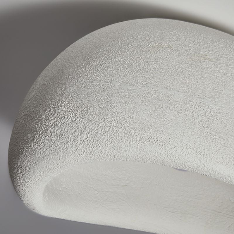 Unlit white Byers shell close-up showing a grainy outer texture and curved pale interior.