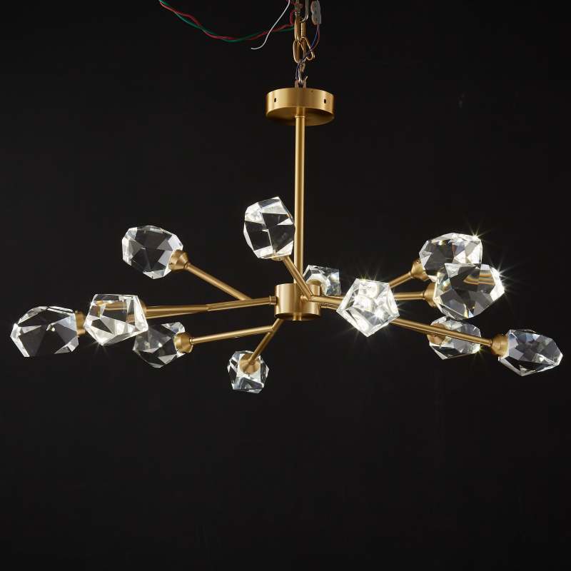 Kristy displayed against black with clear faceted elements, gold-tone branches, a round canopy and wires above it.