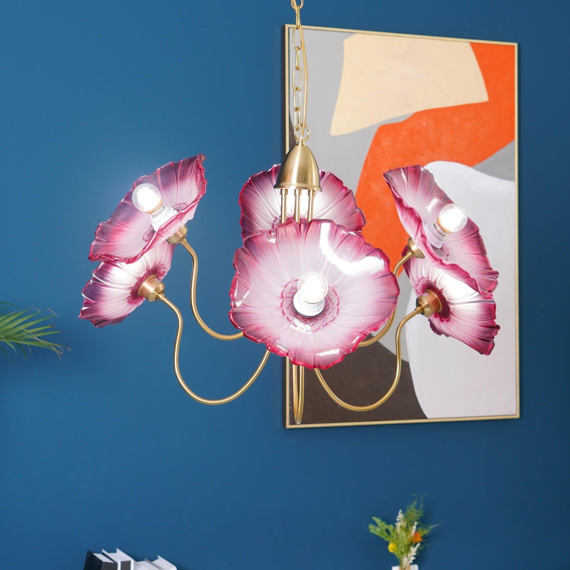 Pink glass flower chandelier against blue wall