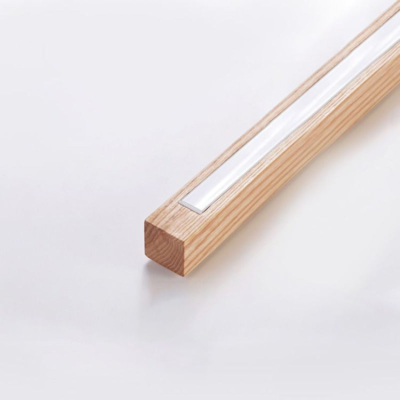 Close-up of a white recessed light insert along a woodgrain bar, with the end face visible