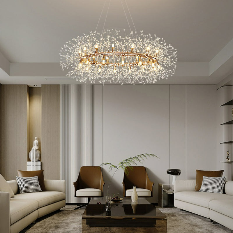 Lili ring pendant above a dark coffee table between cream sofas and tan chairs, with pale paneled walls and green foliage.