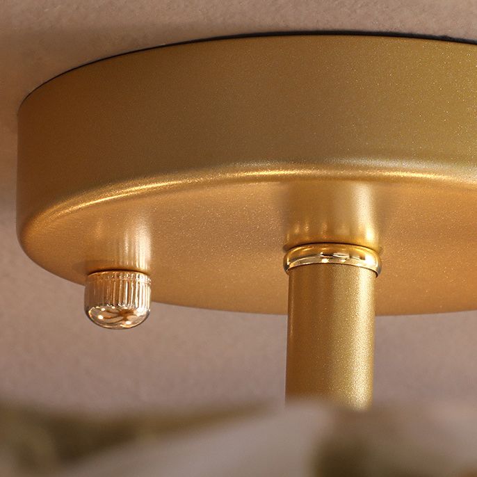 Close-up of Kirsten gold-toned round canopy, edge, thumb nut and ring around the short stem.