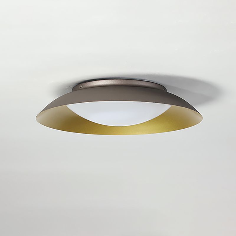 Carins side view beneath a white ceiling, with a dark outer brim, gold-tone interior and white convex cover.