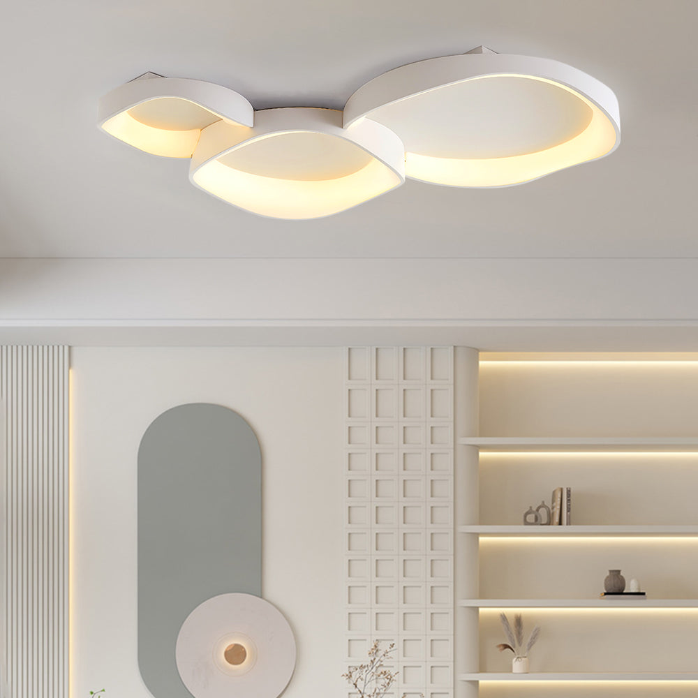 Three white Arisha bowls above grey oval wall decor, white circular ornament with gold centre and illuminated display shelves.