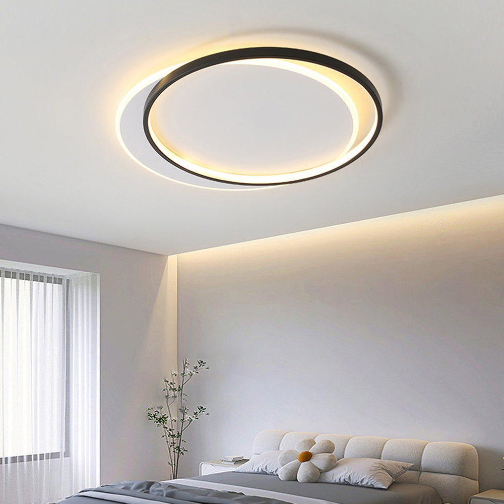 Round Quinn ceiling light over cream upholstered bed, pale bedding and flower cushion, with white cabinet, plant and sheers.