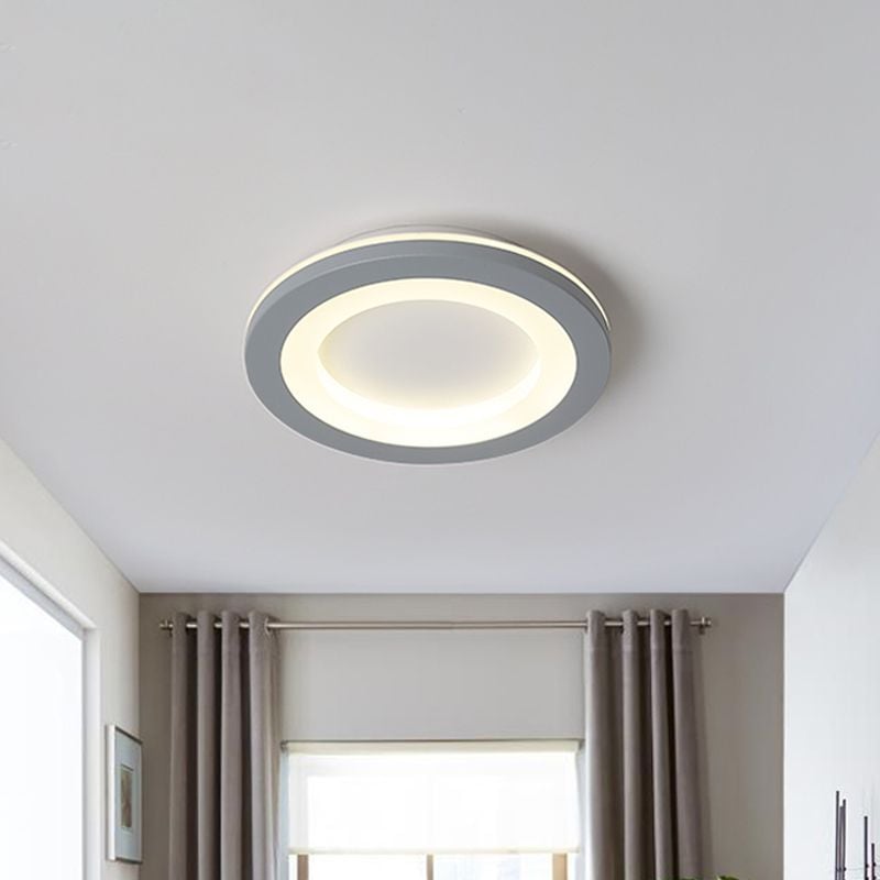 Circular gray light with a yellow-lit ring and pale inset center above a window and curtains
