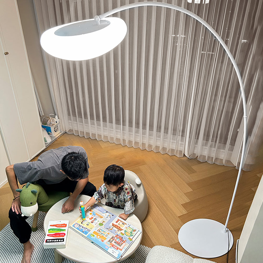 Minori arc lamp pictured above a small table where people are reading.