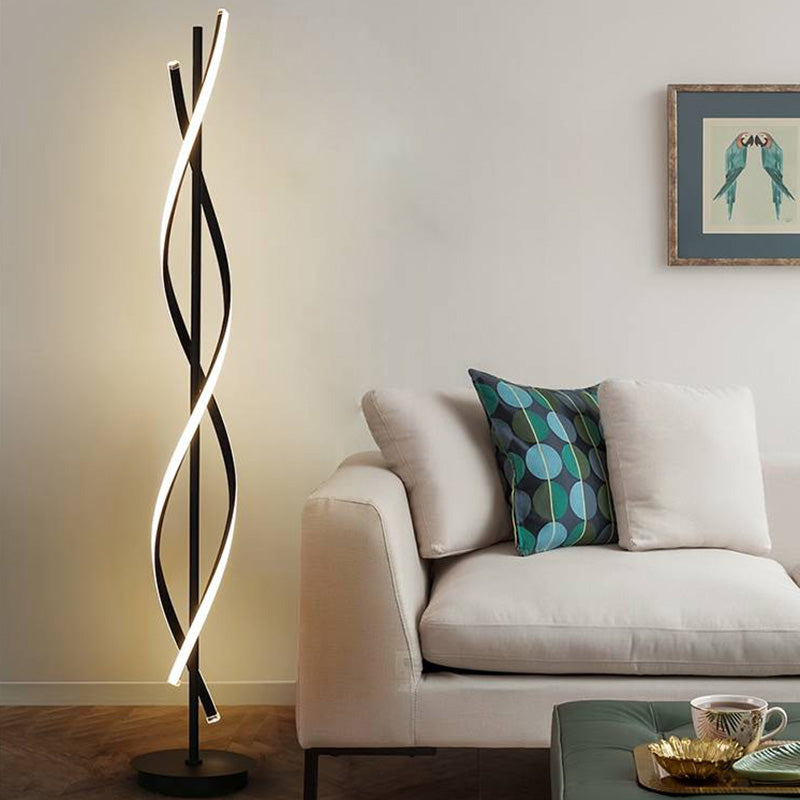 Illuminated black Louise floor lamp beside a cream sofa with a blue-green cushion and framed bird artwork