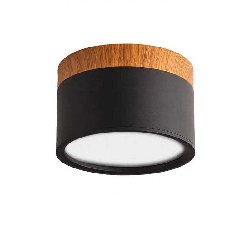 Unlabeled black Morandi cylinder on white backdrop, with textured housing, wood-look upper band and pale diffuser.