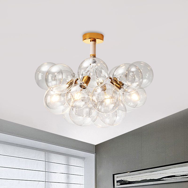 Gold-tone four-light clear globe ceiling fixture above a gray corner and framed picture