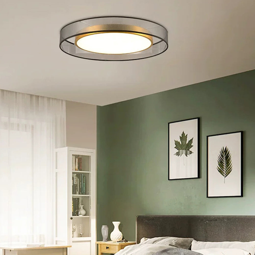 Glowing Quinn above a bed against a sage-green wall with framed leaf prints, white cabinet, wooden bedside unit, vases and sheers.