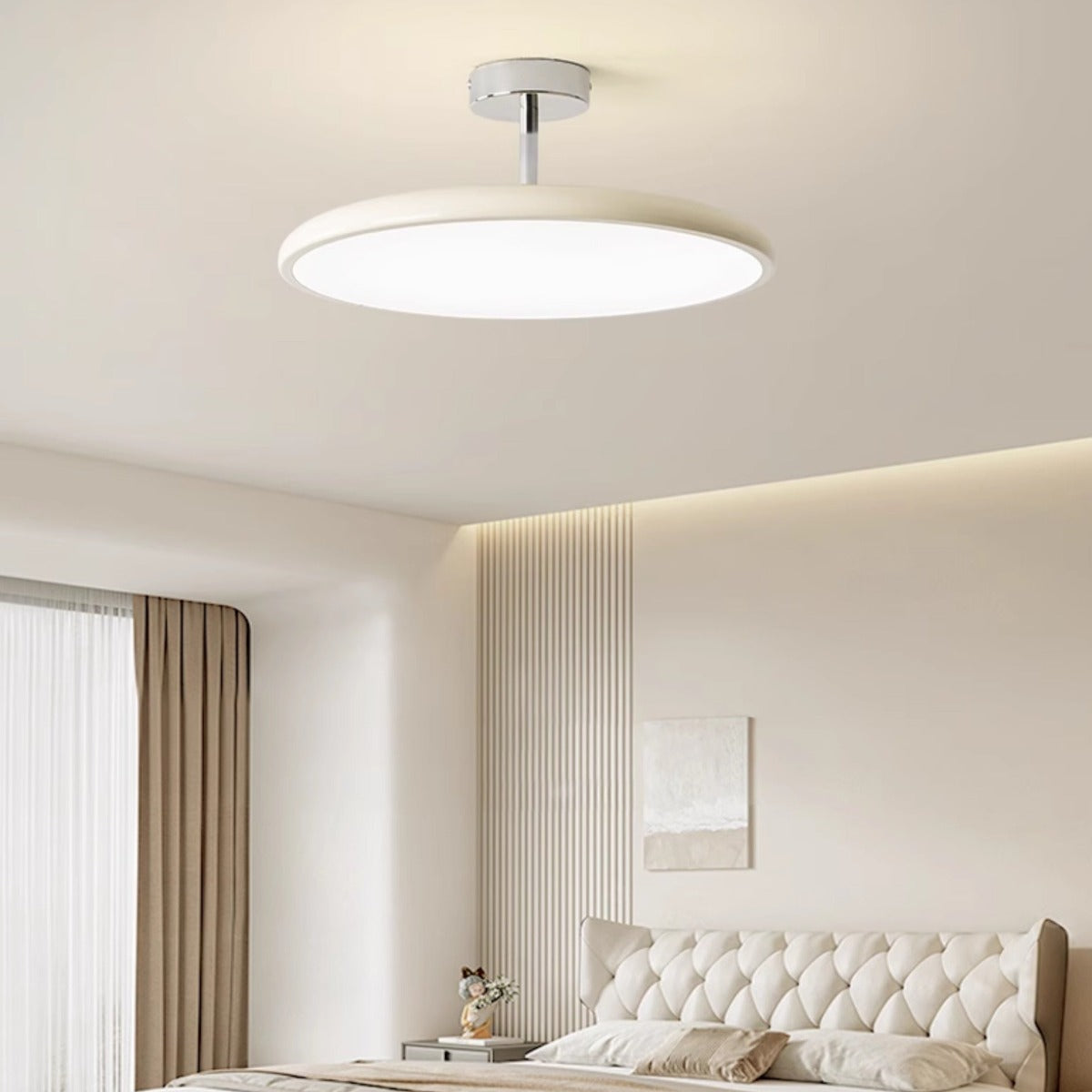 Cream Valentina disc ceiling light near a window in a bright neutral bedroom.