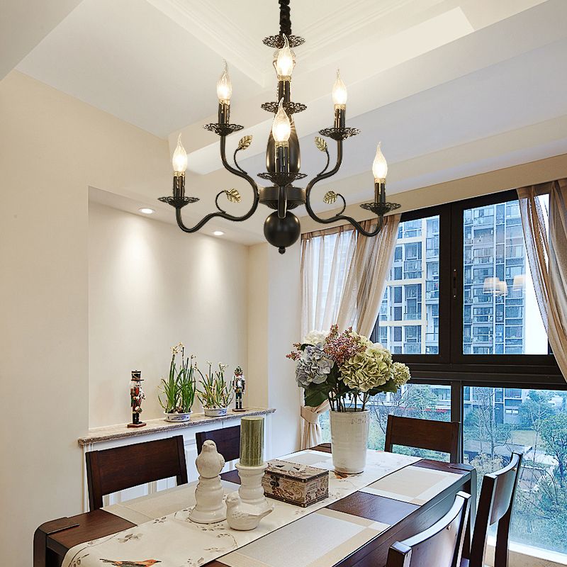 Black 6-Light Marilyn above a wood dining table with flowers and pale placemats, beside large windows and pale curtains.