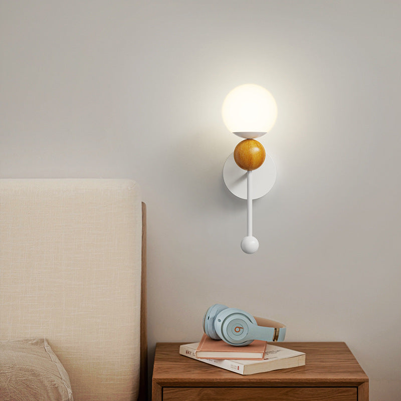 Wood-tone Hailie wall light illuminated above a bedside table