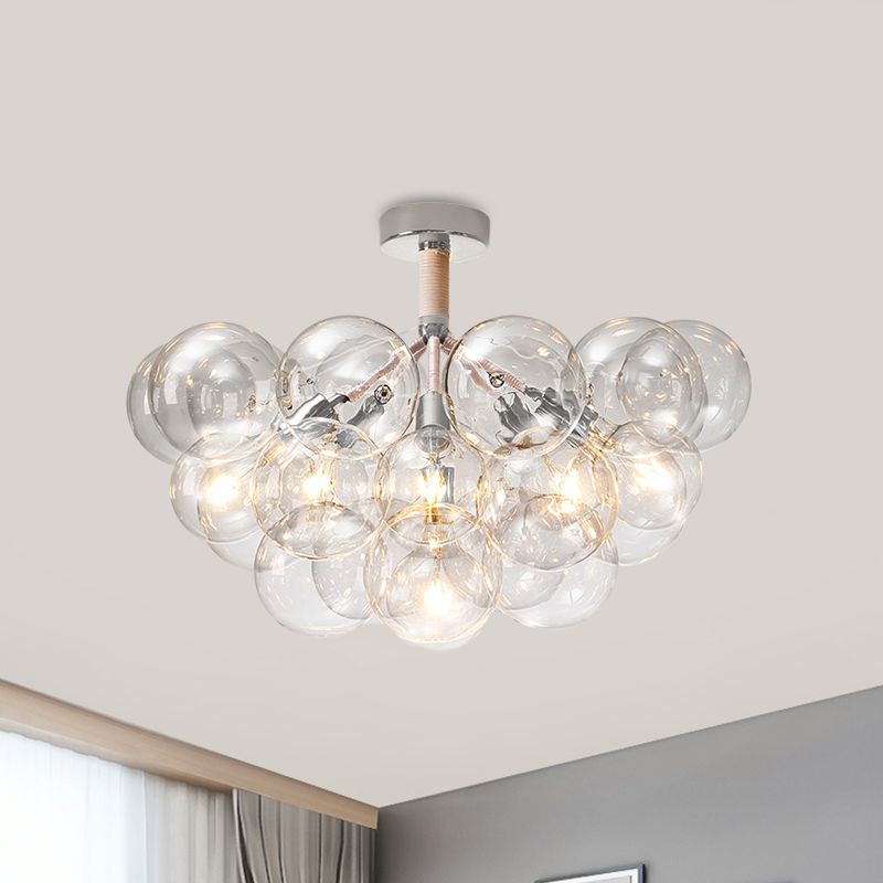 Chrome six-light bubble globe cluster illuminated above a ceiling and curtain corner