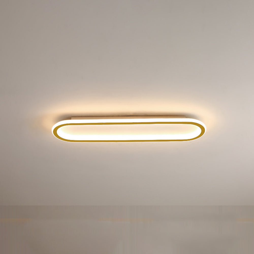 Gold Quinn ceiling fixture with pale centre, rounded ends, luminous white border and warm-looking surrounding light.