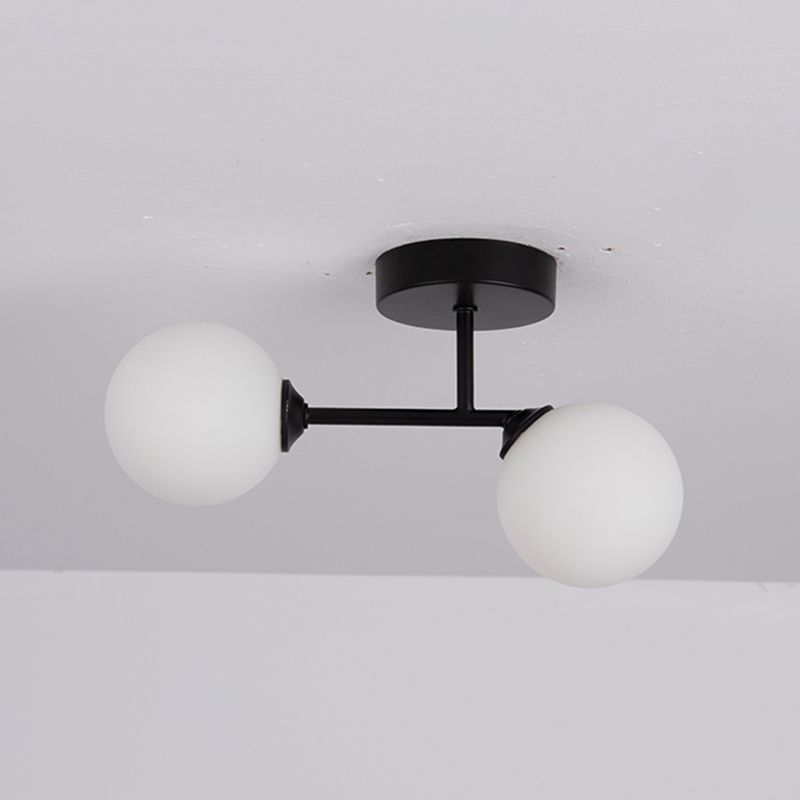 Black Valentina close-up showing the short stem and crossbar with two unlit white globes, one sitting slightly lower.