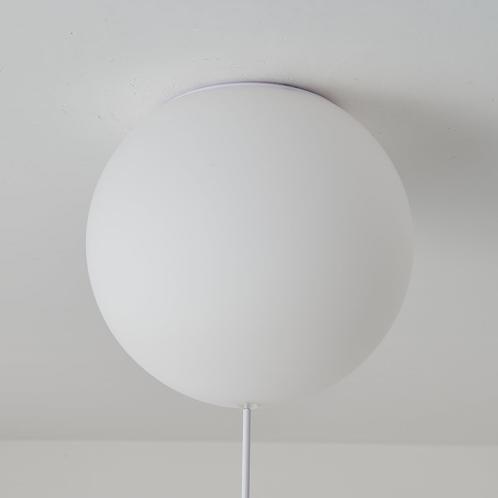 Close-up of the pale round Fateh globe at the ceiling, showing its upper mounting rim and a partly visible lower vertical link.