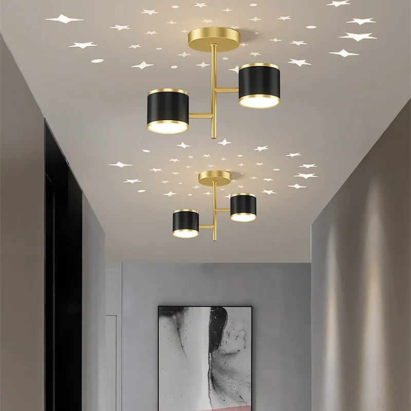 Gold-frame Madina cylindrical ceiling lights along hallway, with illustrated star dots, framed art at end and black cabinet