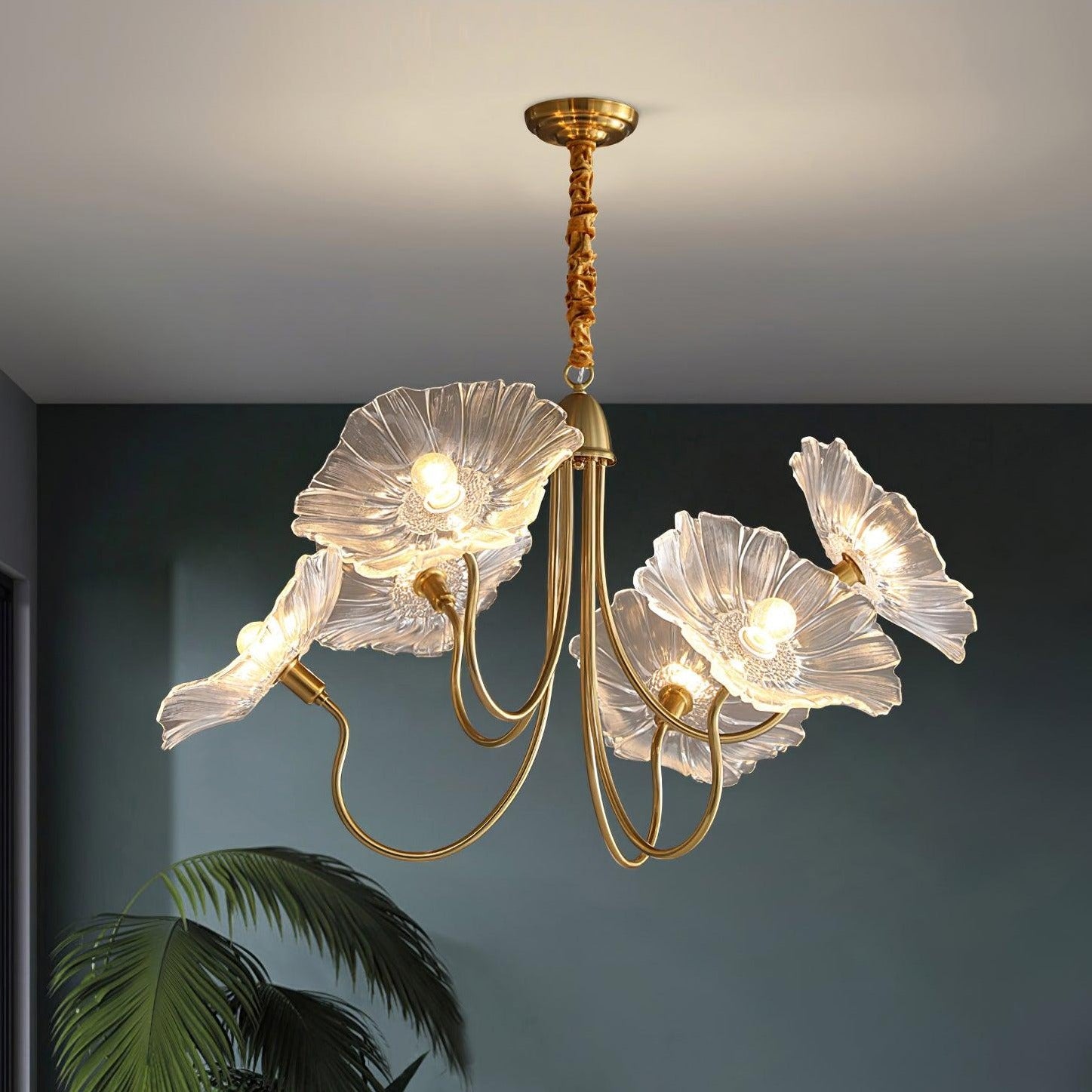 Clear flower chandelier near dark green wall