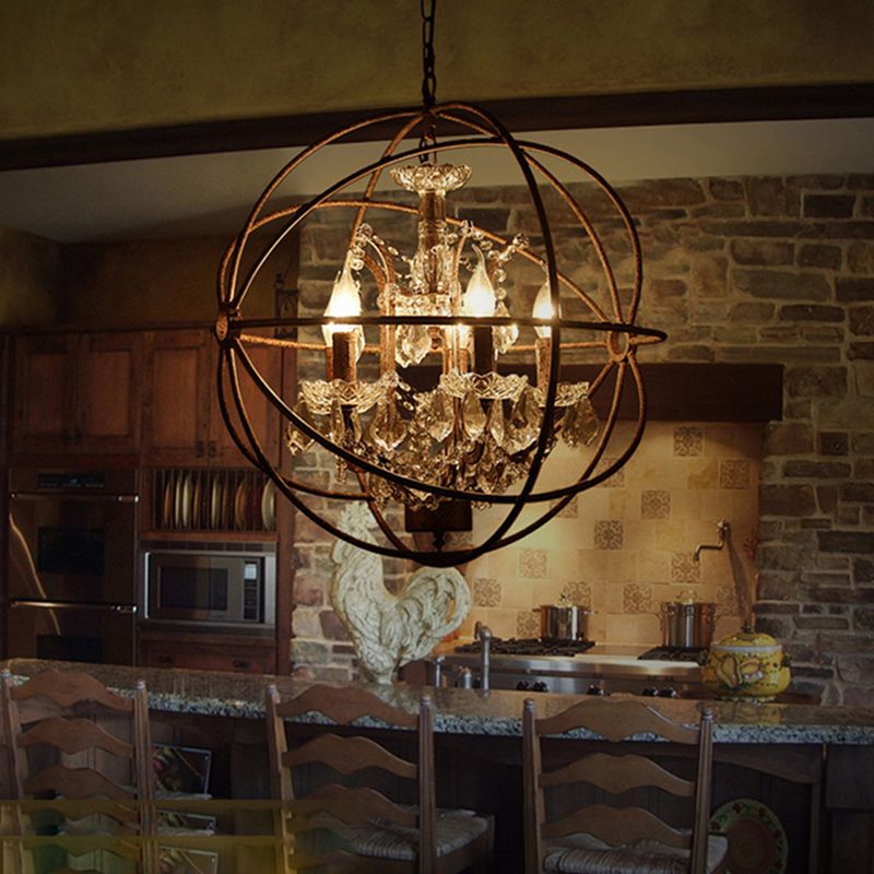 Rust Kristy cage pendant illuminated above a table in a brick-walled interior.