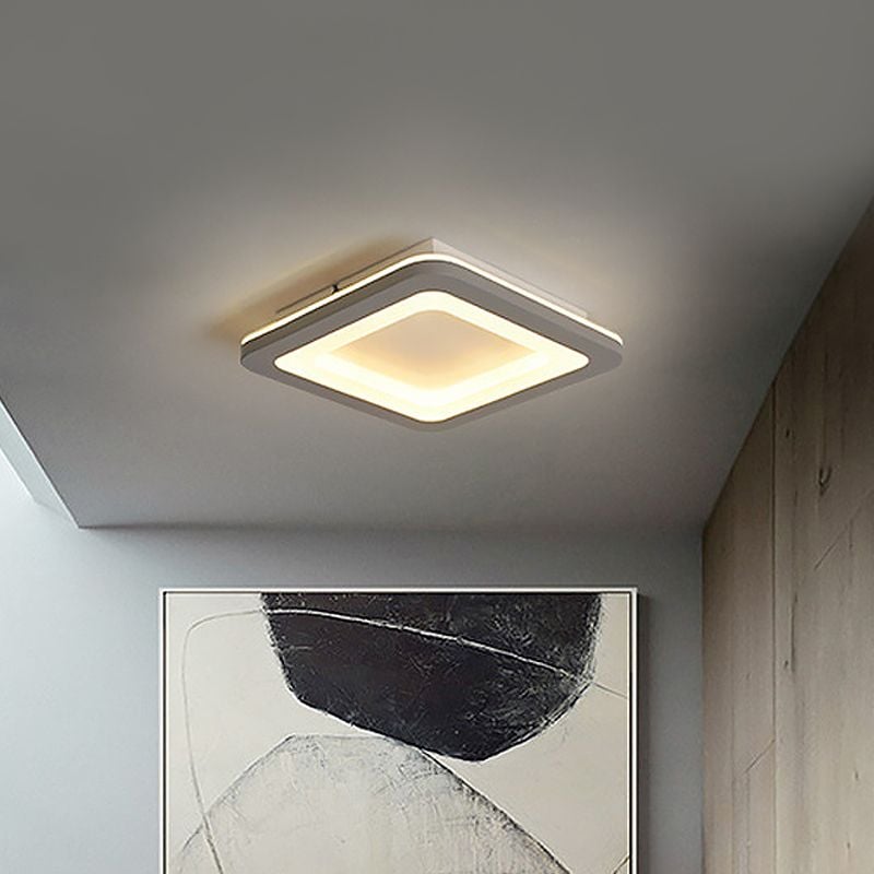 Rounded square gray ceiling light with yellow-lit outline above artwork and a wardrobe