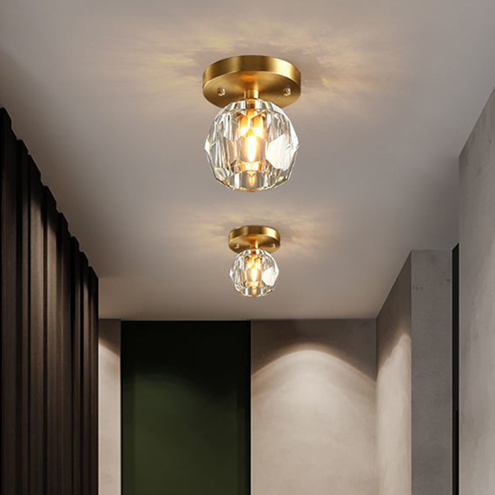 Closer view of Kirsten fixtures in a hallway with black curtains, white walls, dark green door and partial round cabinet.