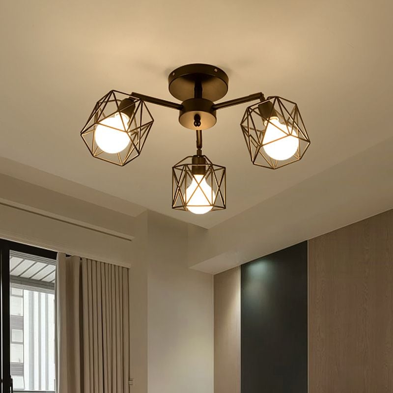 Three-light Herbert cage fitting with lit bulbs above a window, folded curtains, wood-textured wall and dark rectangular panel.