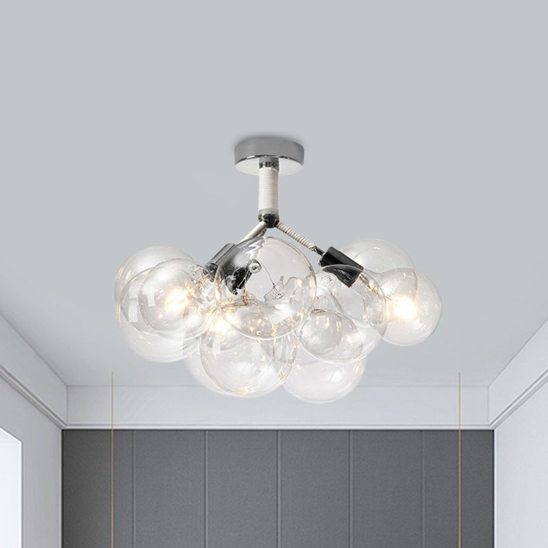 Chrome three-light bubble globe ceiling fixture illuminated above a dark wall
