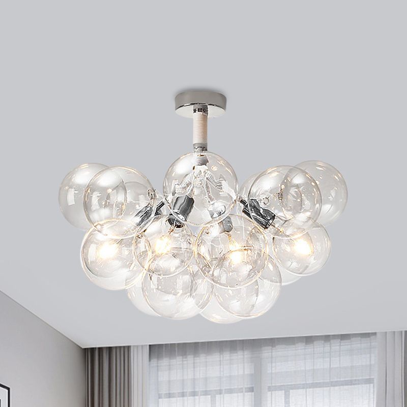 Chrome four-light clear globe cluster illuminated near a window and curtains